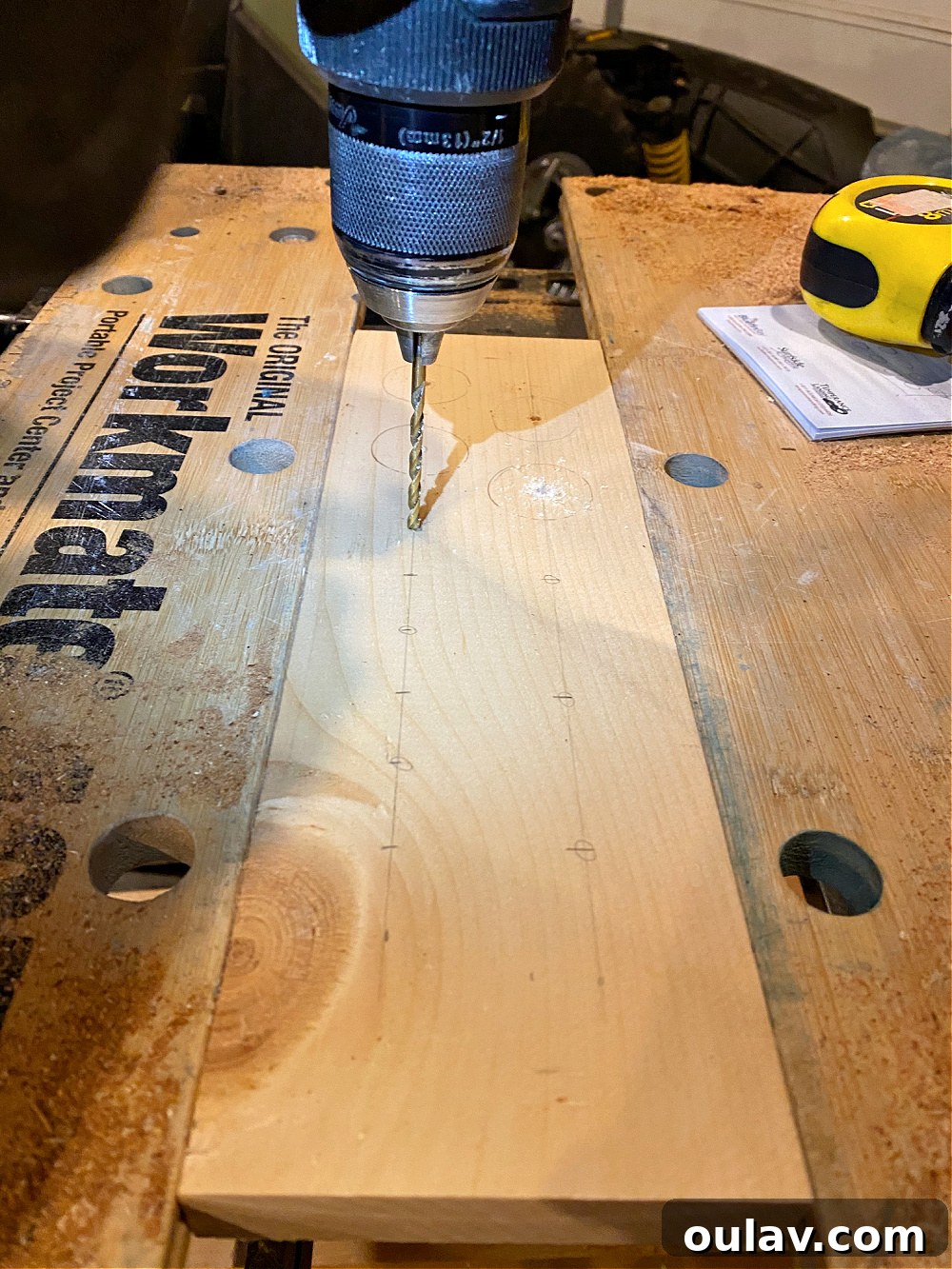 DIY wooden egg holder - Pre-drilling a pilot hole in the center of a marked spot to guide the hole saw for an accurate cut.