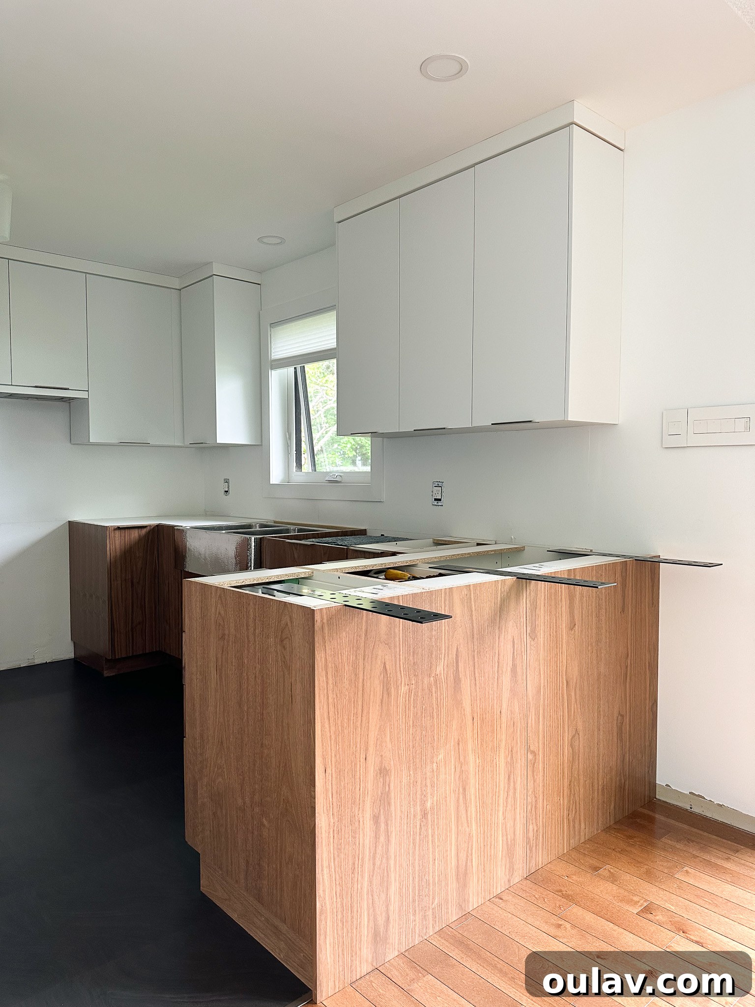 Kitchen island with temporary wooden support brackets installed for stone counter overhang