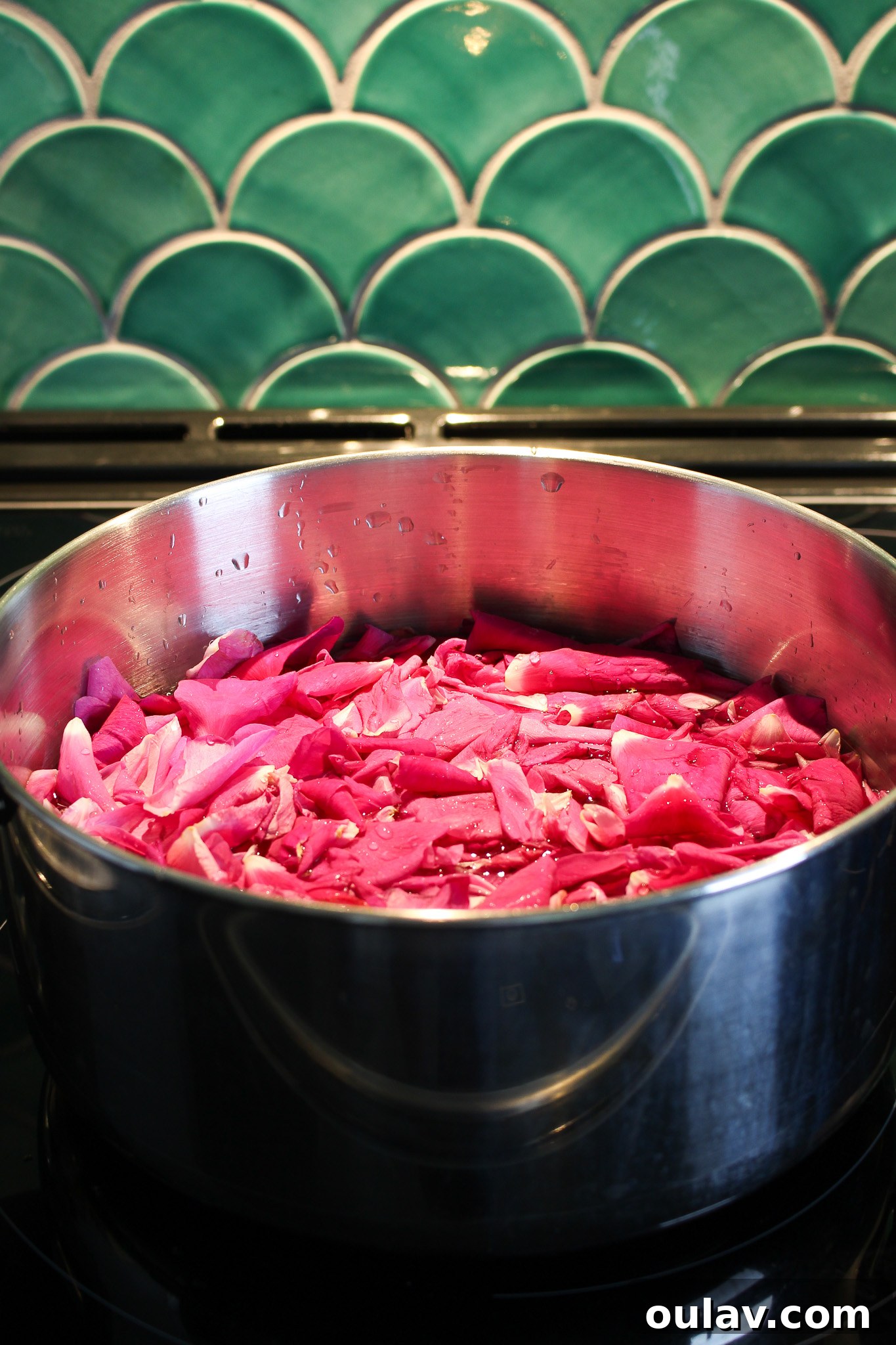 Rose petals covered with water gently simmering in a pot on the stovetop.
