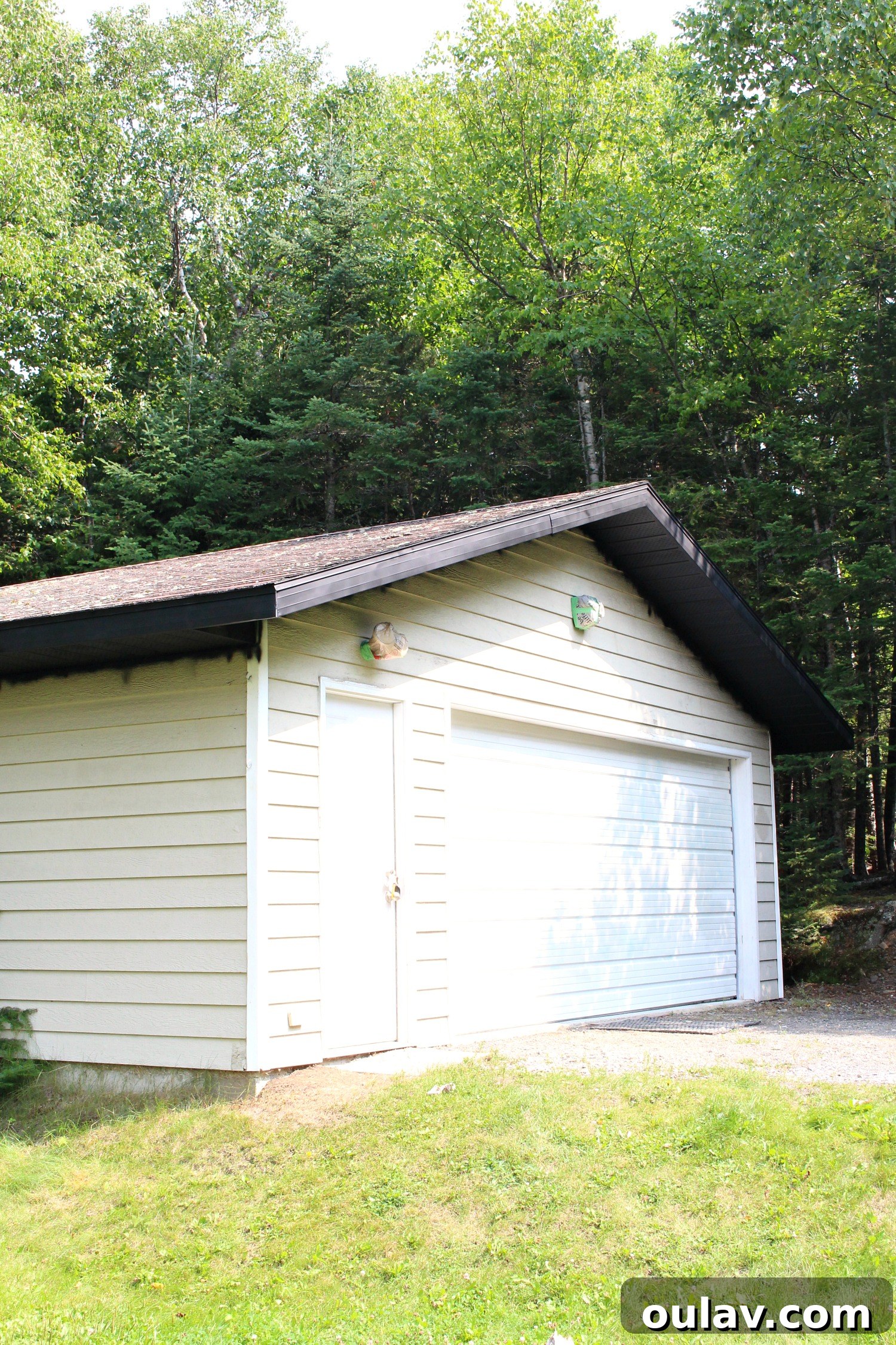 The action of spray painting a soffit, demonstrating proper technique for even coverage.