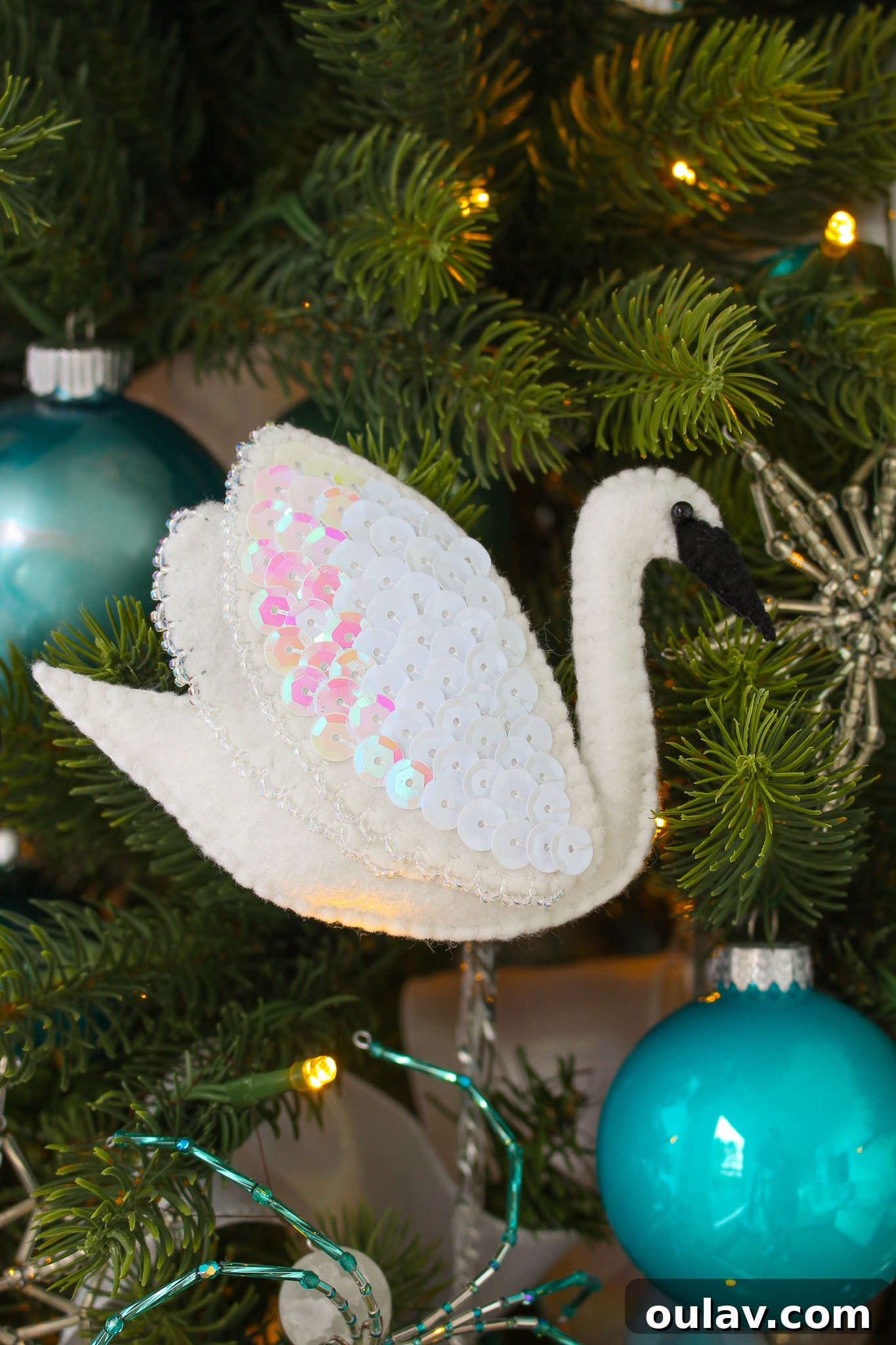 Stitch Your Own Felt Swan Ornament 4 Handmade felt swan ornament hanging on a Christmas tree, sparkling with sequins