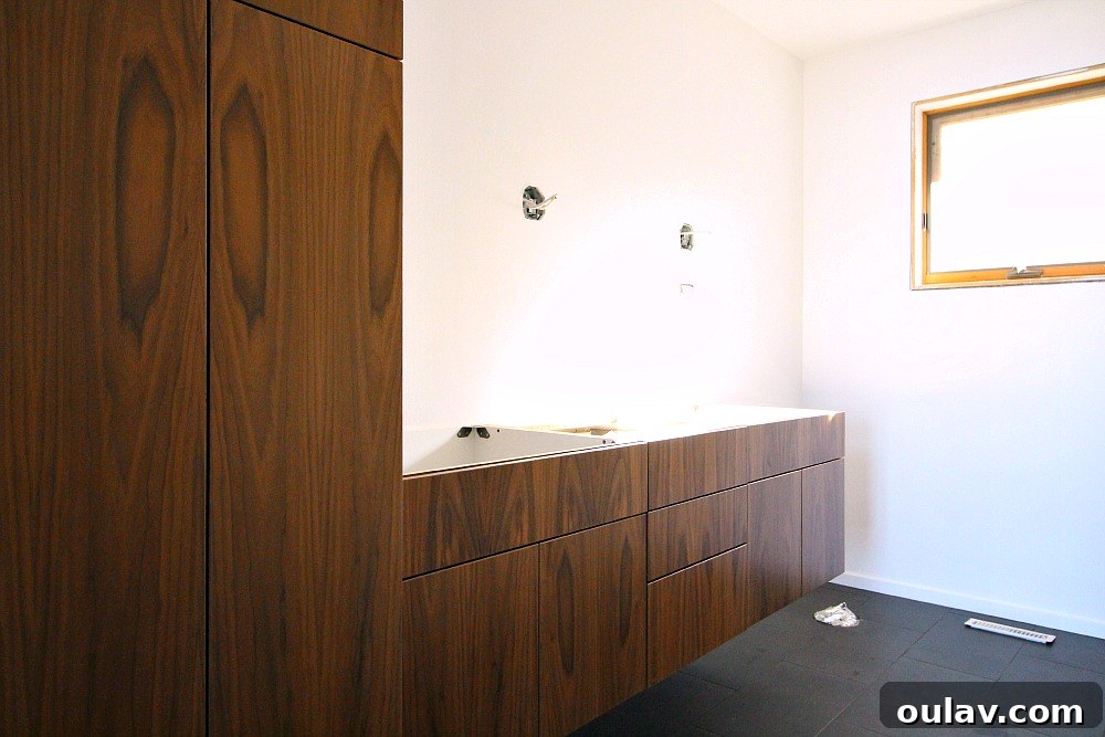 Sleek Simplicity: Floating Walnut Cabinets Transform This Bathroom 2 Newly installed floating walnut vanity in a modern bathroom.