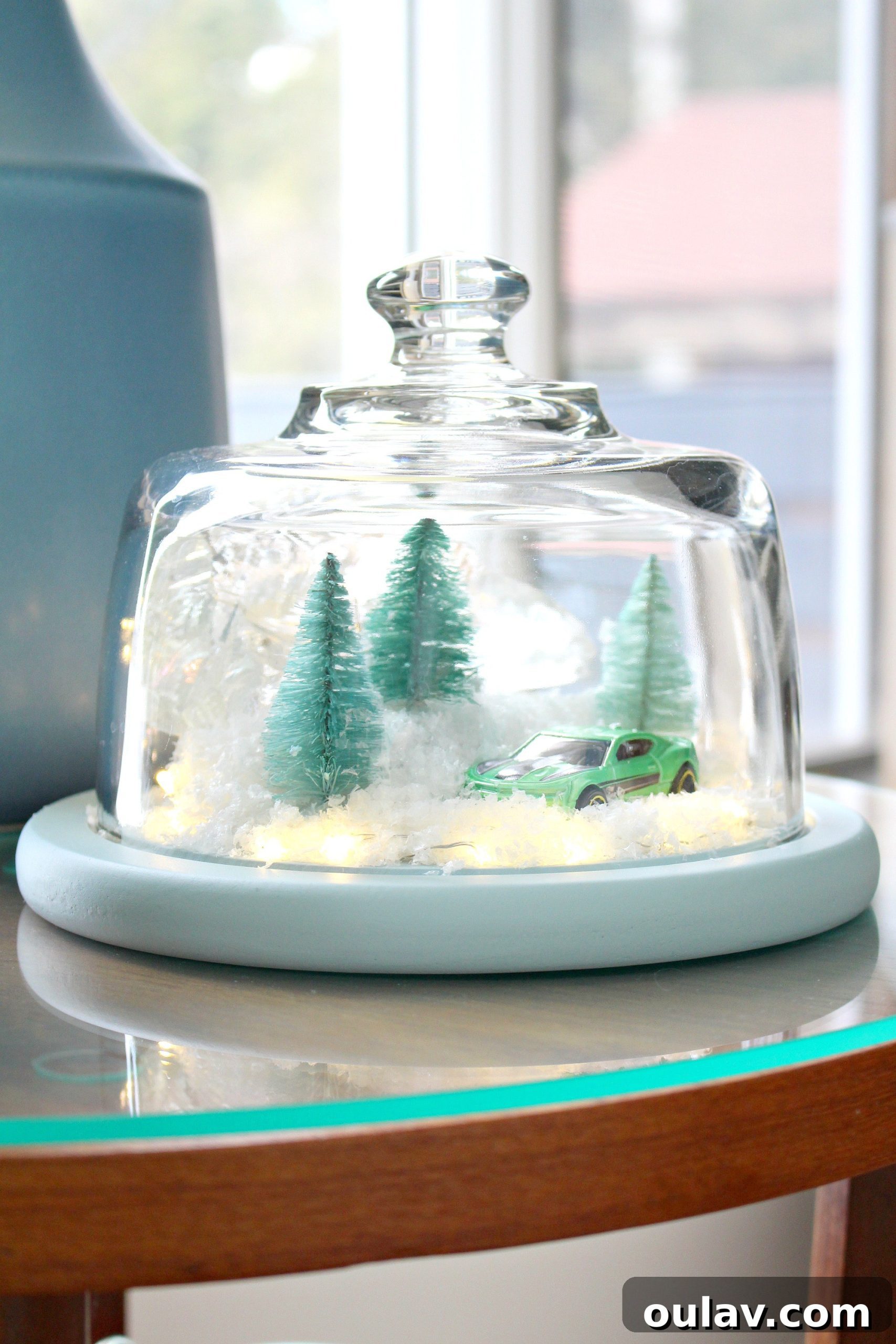Gearhead's Festive Display Dome 13 A charming DIY Christmas cloche featuring a green Camaro Hot Wheel, bottle brush trees, and soft fairy lights creating a cozy ambiance.