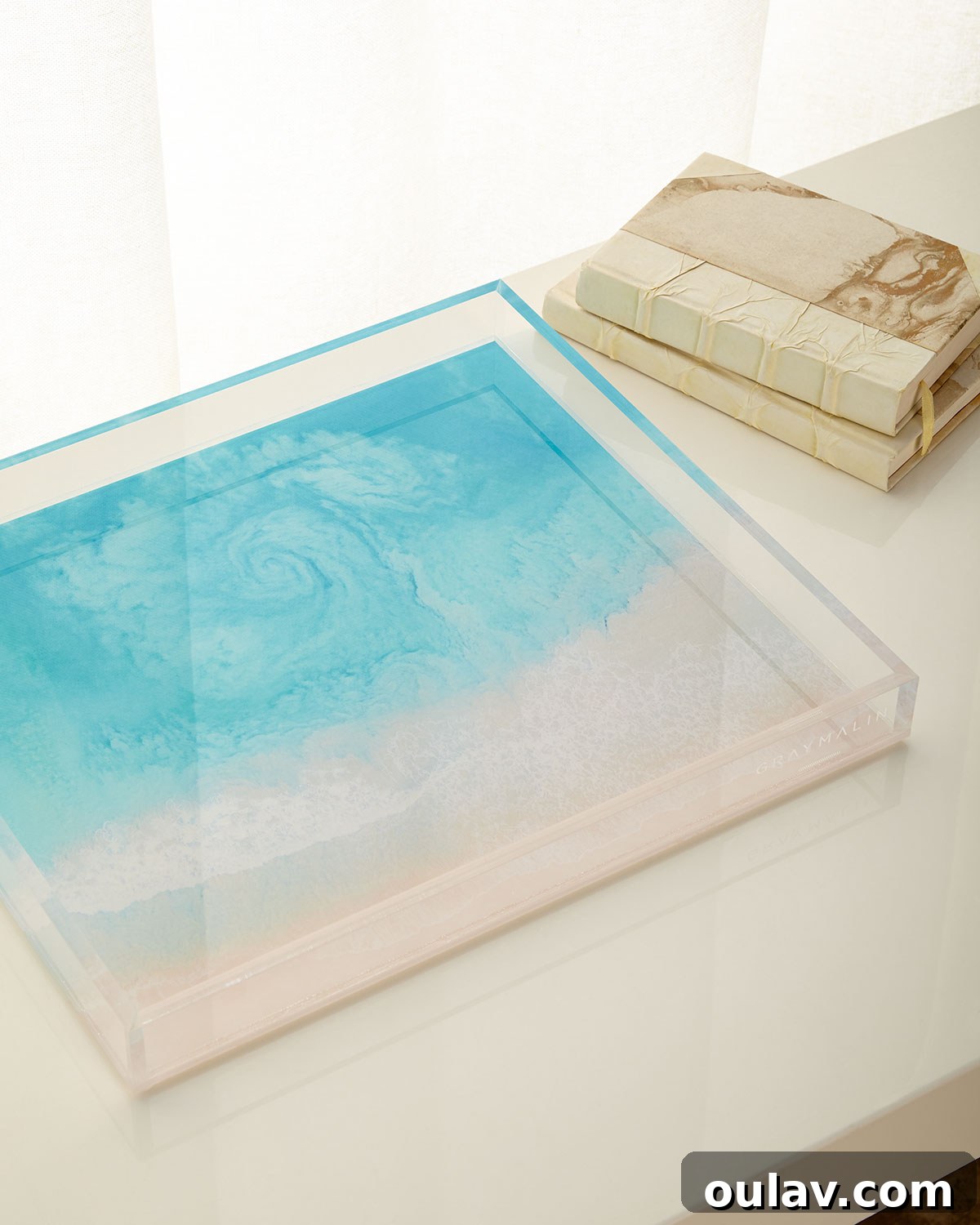 Holiday Haven: 25 Delightful Gifts for Homebodies 28 A decorative tray featuring Gray Malin's 'Hawaii Swirl' aerial beach photography, on a coffee table.