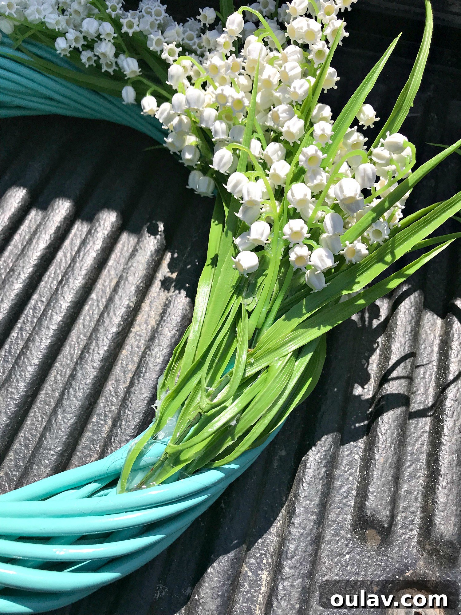 Close-up of faux Lily of the Valley flowers being cut into smaller stems for wreath making