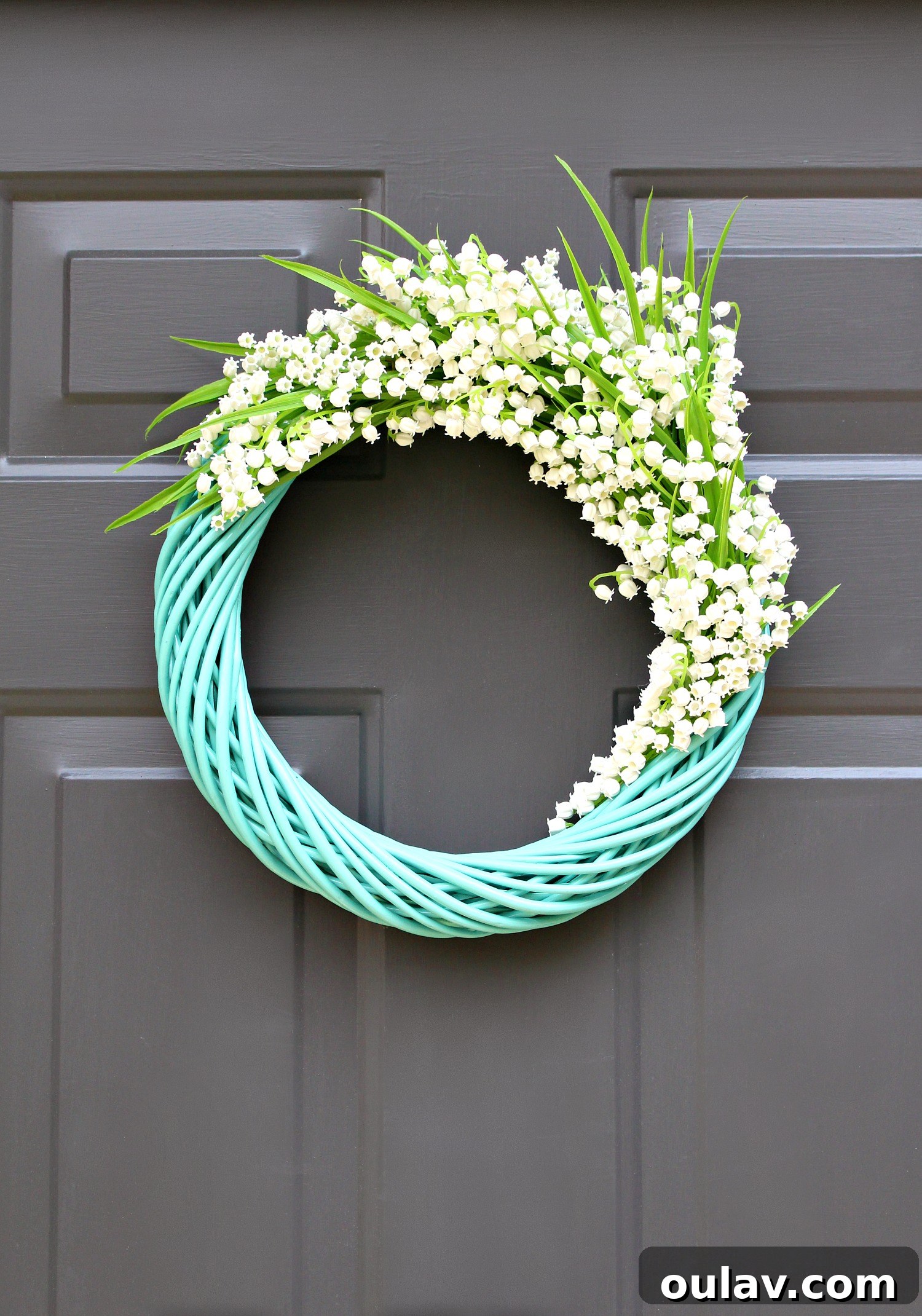 Effortless Turquoise Lily Faux Wreath 5 Stunning turquoise Lily of the Valley wreath adorning a dark garage door, boosting curb appeal