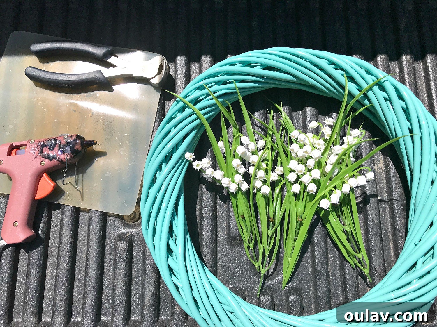Effortless Turquoise Lily Faux Wreath 6 Arrangement of craft supplies for DIY faux flower wreath, including a thrifted wreath form