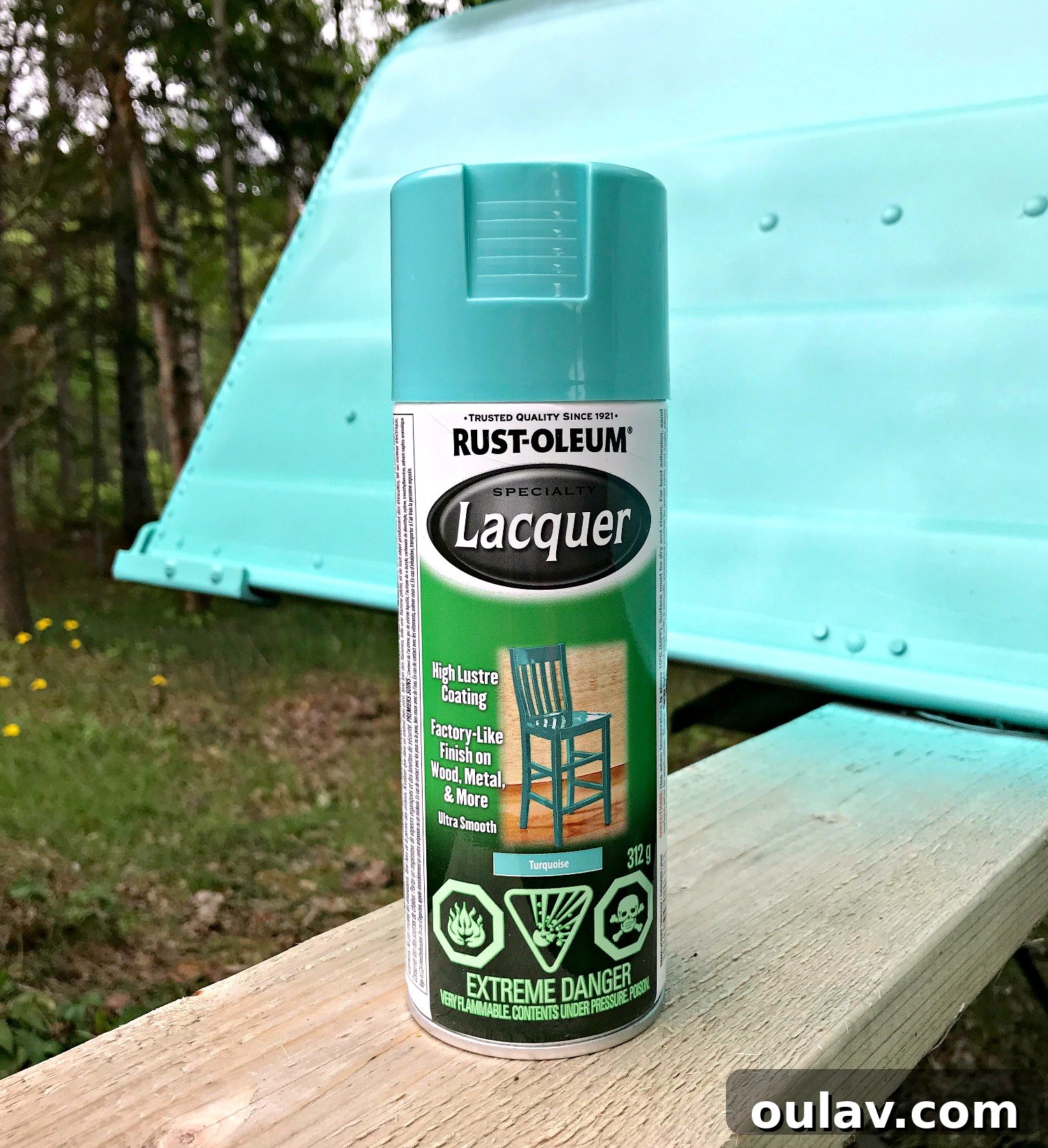 Working meticulously to apply even coats of turquoise spray paint on the boat's hull.