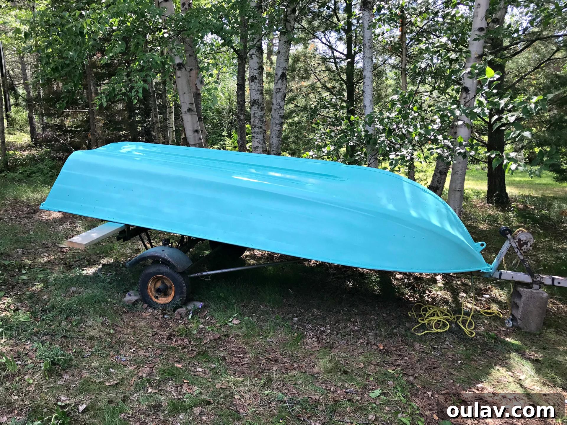 The stunning turquoise finish beginning to emerge on the boat's exterior during the painting process.