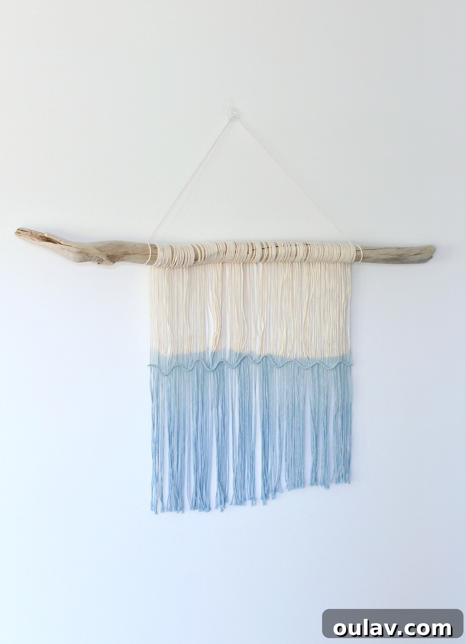 Handcraft Your Own Macrame Driftwood Wall Art 28 Two images of the finished macrame and driftwood wall hanging after dip-dyeing and initial trimming, displayed against a wall.