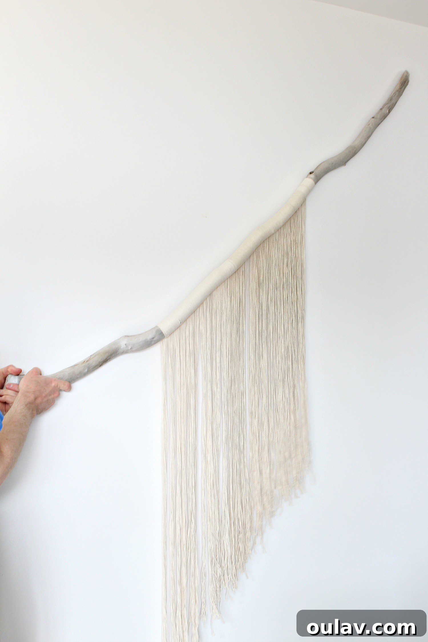 Handcraft Your Own Macrame Driftwood Wall Art 5 A close-up of the large macrame project, showing the initial string arrangement on a piece of driftwood.